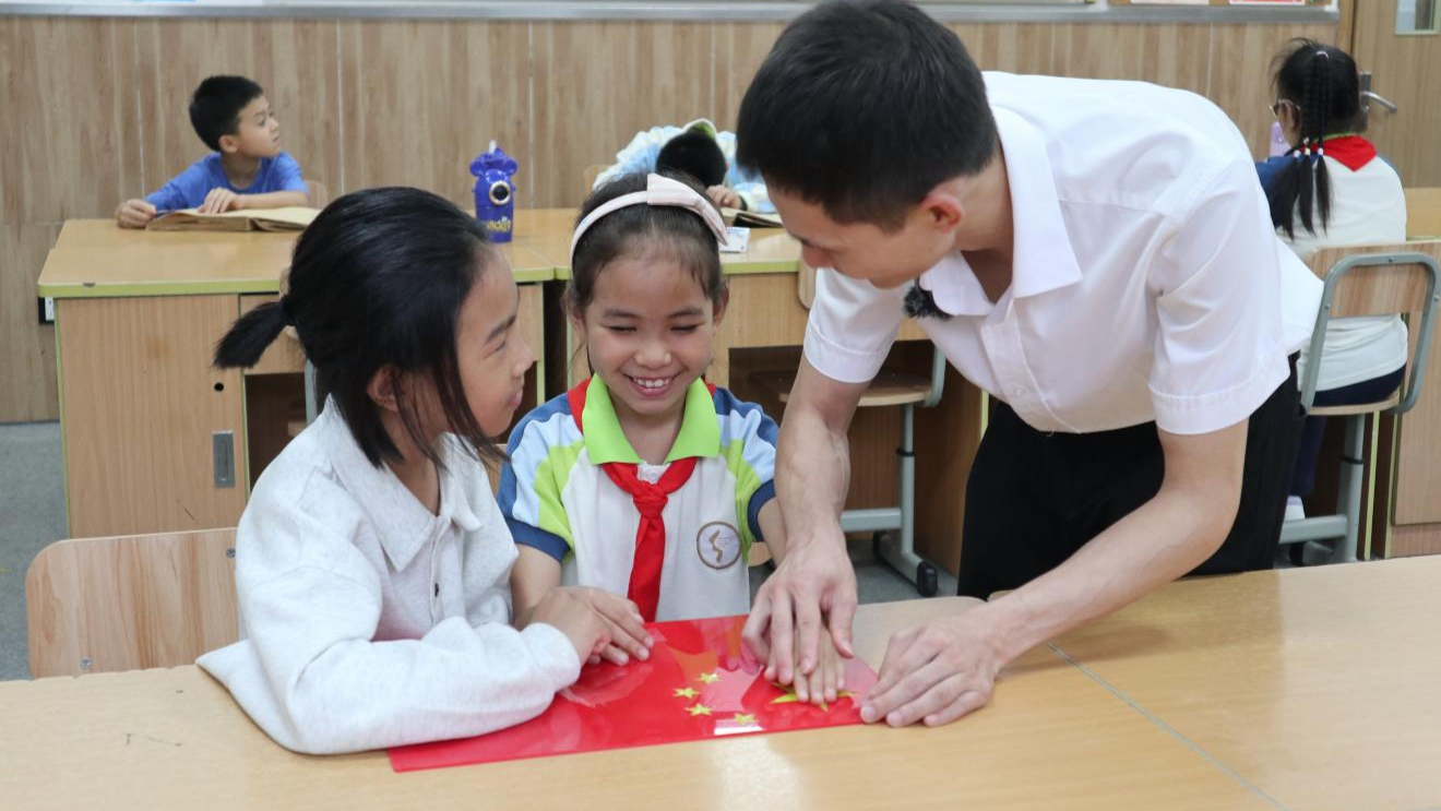 学生触摸五星红旗上凸起的五角星(央广网发 杨文杰 摄)