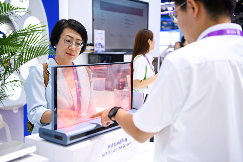 9月18日,在南宁国际会展中心,观众在了解多语言AI透明屏。新华社记者曹祎铭摄