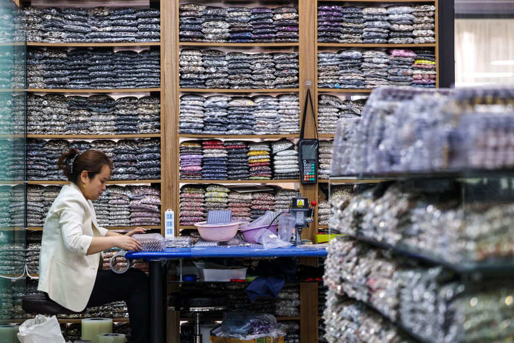 2025年3月,在温州永嘉县桥头商贸中心一家经营钮扣产品的店铺内,员工在打包钮扣产品。新华社记者 江汉 摄