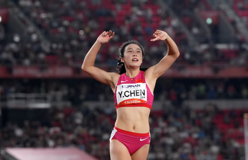 9月25日,中国选手陈妤颉在爱知·名古屋亚运会田径项目女子100米决赛冲线后庆祝。新华社发(吕小炜摄)