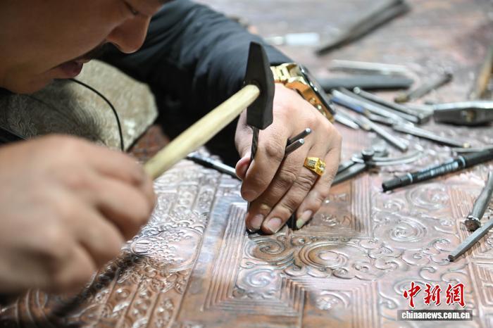 图为西藏雪堆白技工学校金属技艺教师罗布顿珠，正在专注进行金属锻造创作。贡嘎来松 摄