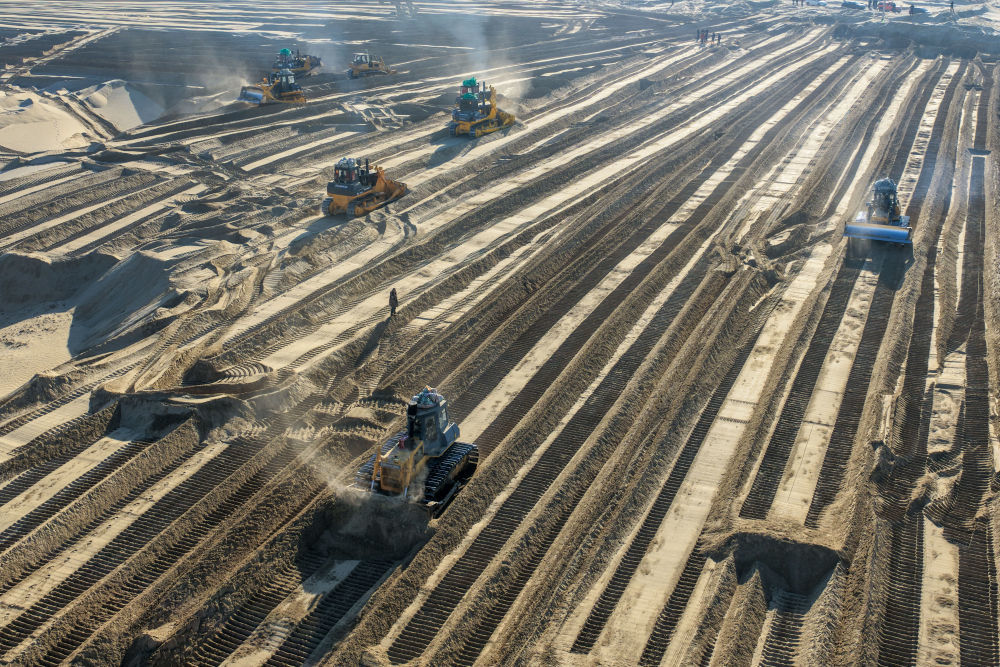 在新疆和田地区墨玉县喀瓦克乡，大型机械在沙漠中穿梭作业、平整沙地（1月11日摄，无人机照片）。新华社记者 丁磊 摄