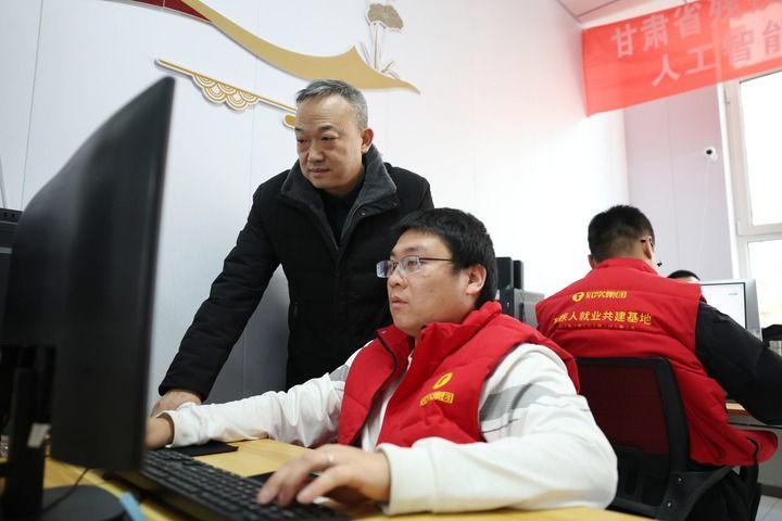 在兰州市心连心社会工作服务中心残疾人就业工坊，社会工作者王生番（左）指导残疾人AI训练师进行数据标注工作（2026年1月14日摄）。新华社记者 陈斌 摄