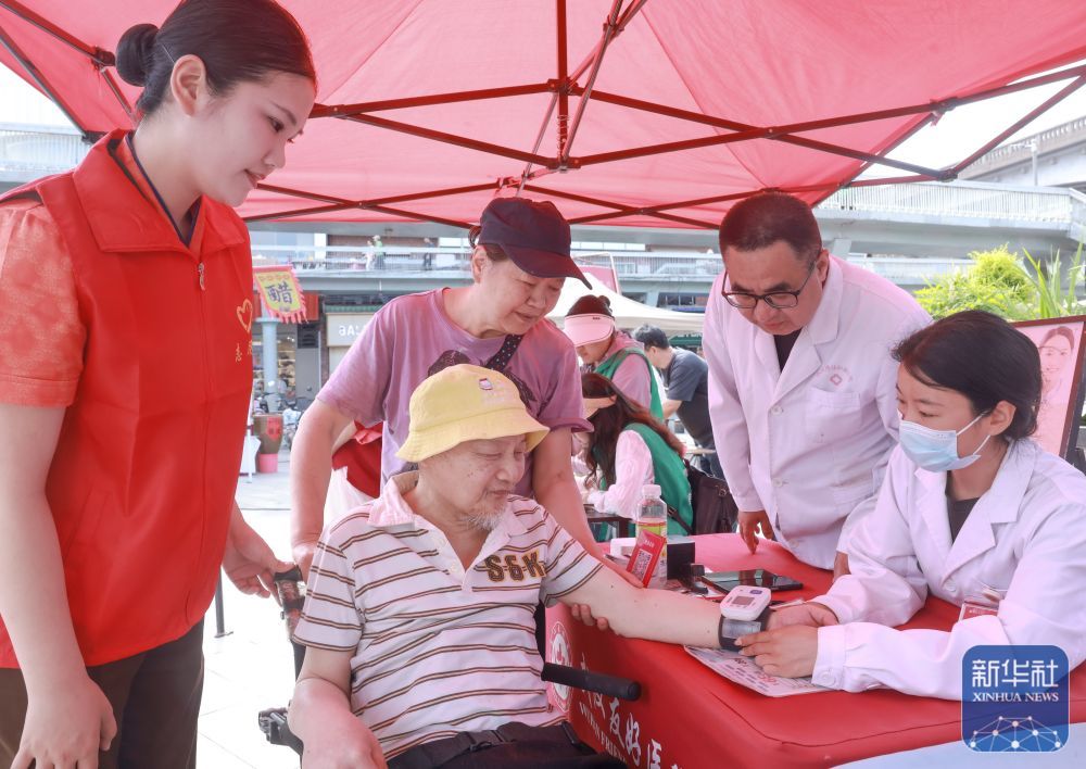 ↑ 5月16日，在湖北省武汉市武昌区，医护人员为残疾老年人检查身体。新华社发（赵军摄）