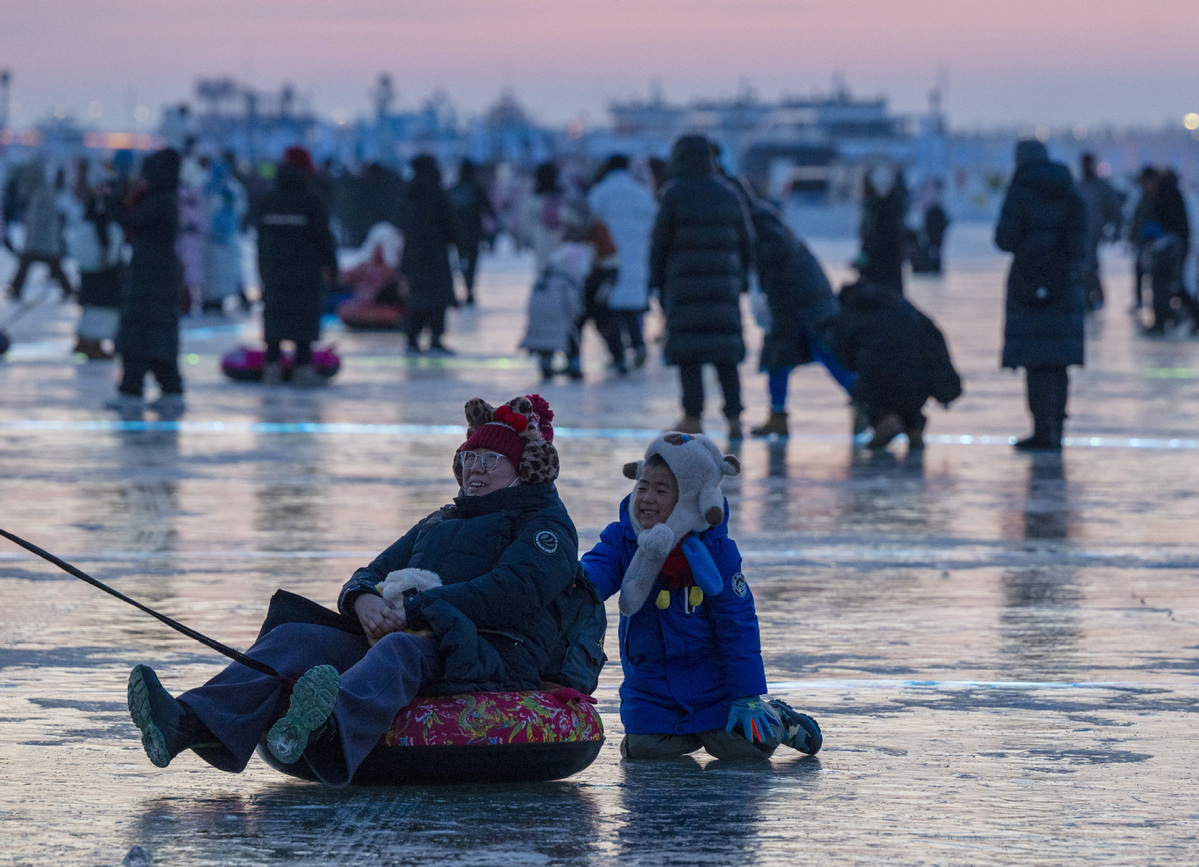 1月2日，人们在第八届哈尔滨松花江冰雪嘉年华园区内体验冰上娱乐项目。（图片来源：新华社）