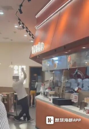 一名白衣男子手持器物在门店操作台上多次敲打