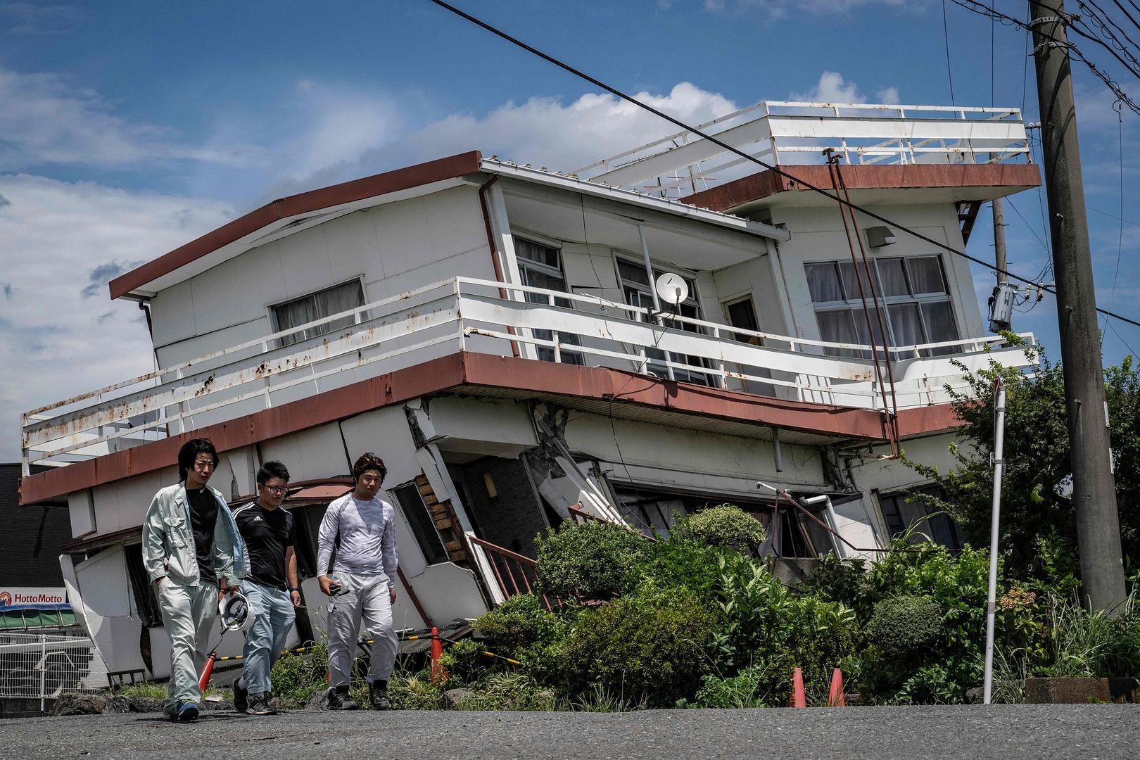 ▲当地时间2026年7月29日，日本熊本县八代市，工作人员走过一栋受损且部分坍塌的房屋 图据视觉中国