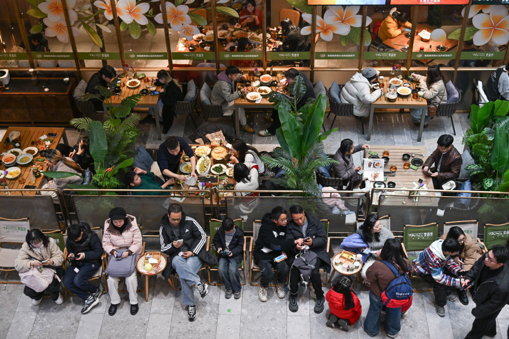 1月2日,在重庆两江新区一商场内,市民在餐饮区排队等待用餐。新华社记者 陈诚 摄