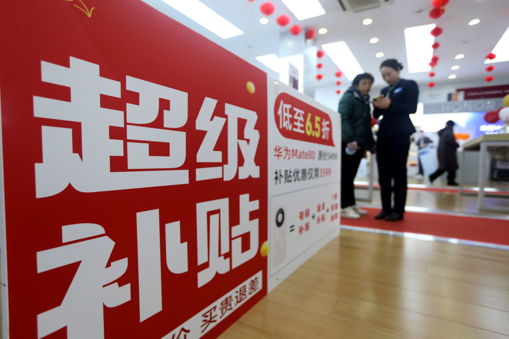 1月6日,消费者在江苏省连云港市连云区一大型手机卖场内挑选新款手机。新华社发(王春 摄)