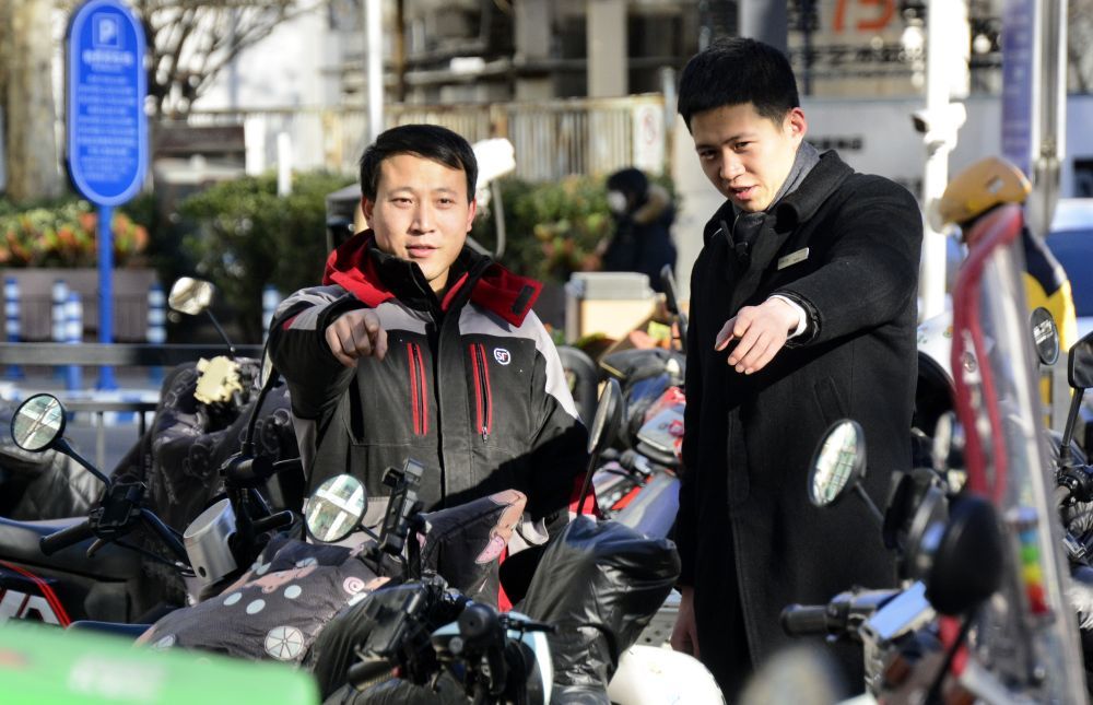 2025年1月16日，在北京市朝阳区八里庄街道，一名快递员志愿者（左）与物业工作人员一起排查社区安全隐患。新华社记者 李欣 摄