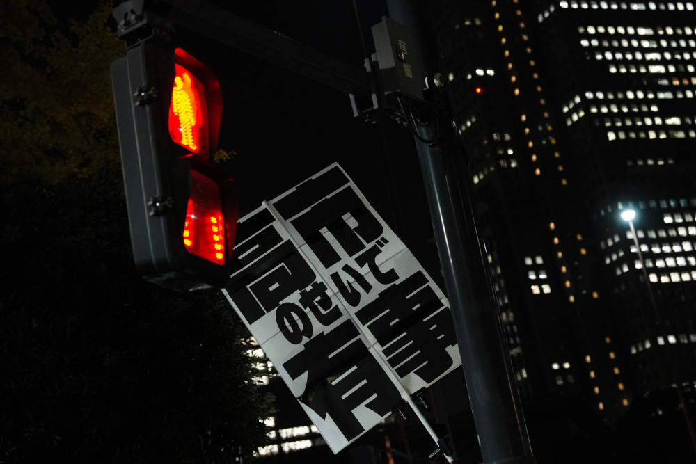 2025年11月21日，在日本东京的首相官邸外，民众手持标语参加抗议活动，要求日本首相高市早苗撤回错误言论。新华社记者贾浩成摄