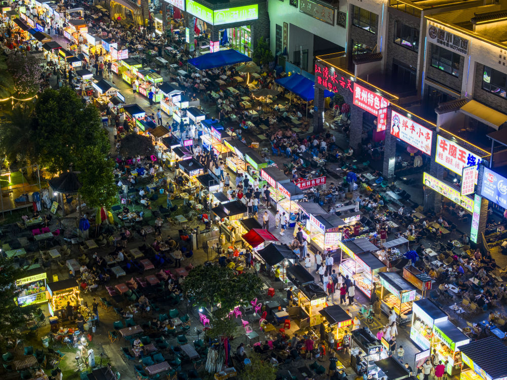 10月2日晚,人们在广西梧州市水云天夜市品尝小吃。新华社发(何华文 摄)