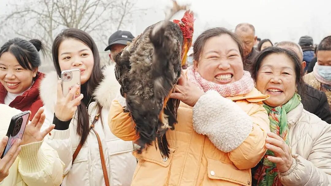 网友展示参加游戏抓到的土鸡。潘政吉 摄