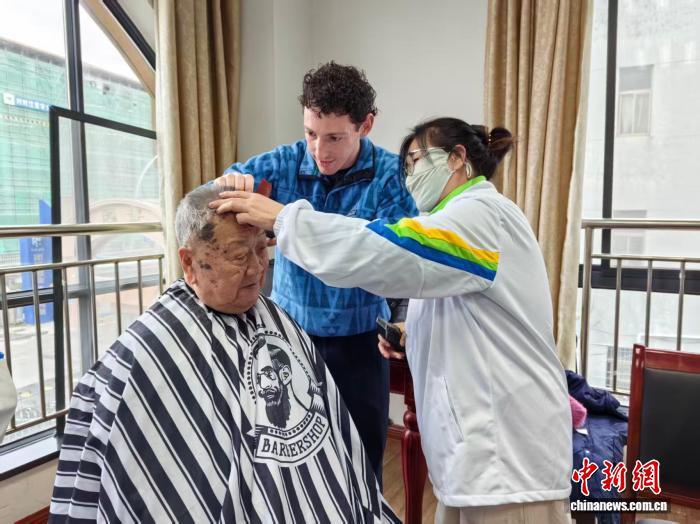 2025年12月21日,费强(中间)为浙江海宁当地老人理发。(资料图,海宁市义工协会供图)