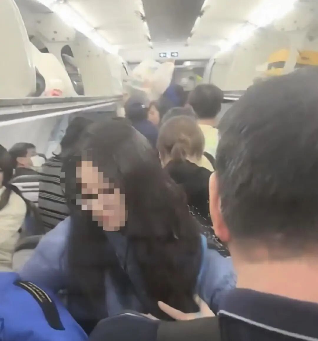 乘客们收拾行李离开机舱。(网络视频截图)