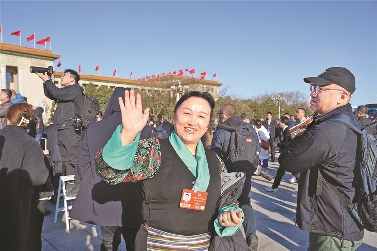 图为住藏全国政协委员巴桑卓玛向记者挥手致意。记者 陶玥 摄