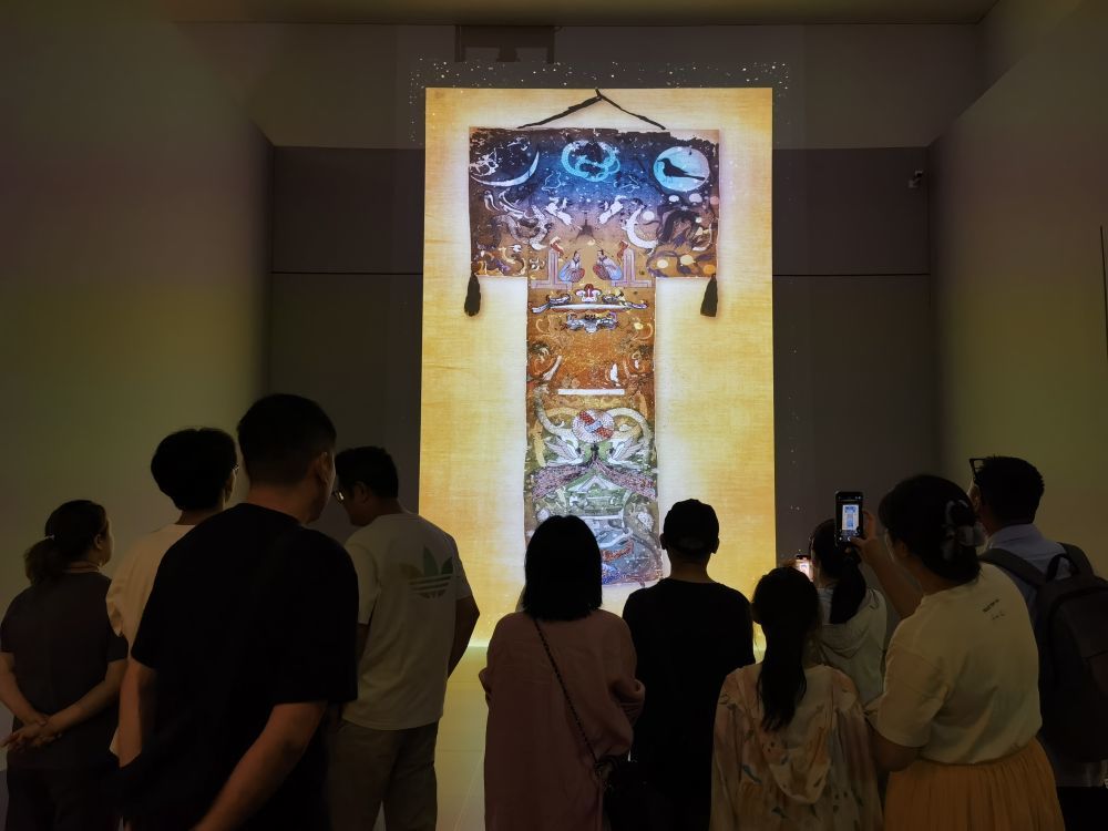 7月25日，观众正在参观围绕马王堆一号墓T形帛画开发的数字化展品。新华社记者 陈爱平 摄