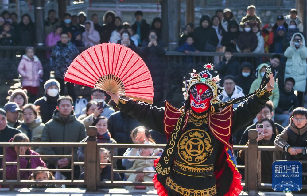 ↑ 1月2日,人们在江苏省句容市宝华山国家森林公园观看川剧变脸表演。新华社发(钟学满摄)