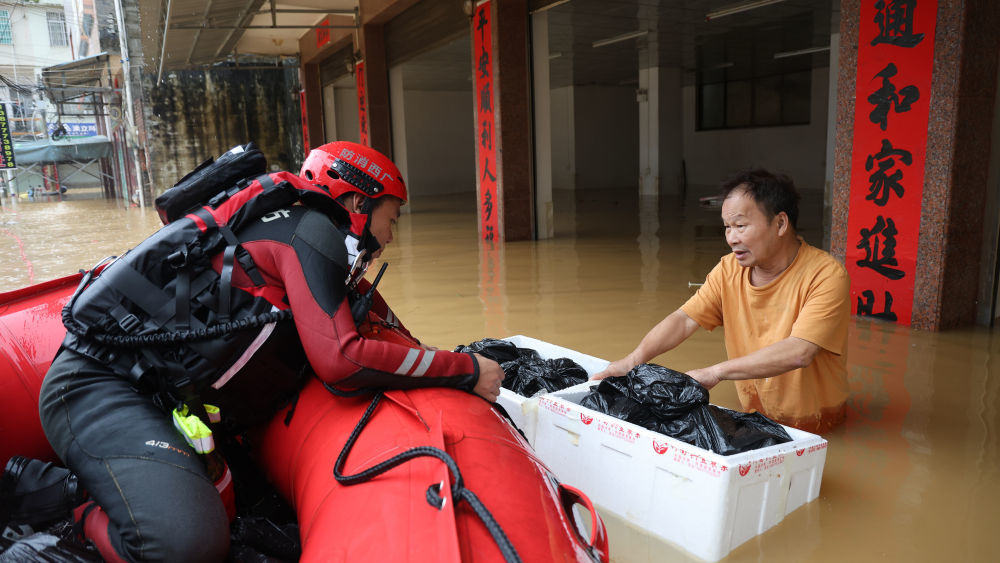 ↑ 7月8日,在广西钦州市钦南区那彭镇,救援人员沿街排查,为受困群众输送应急生活物资。新华社发(敖帅昌 摄)
