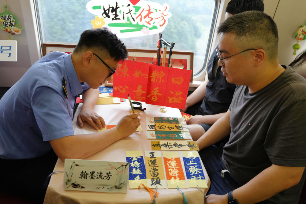 6月17日，由福州开往上海的G1634次列车的工作人员为旅客书写端午祝福语。新华社发