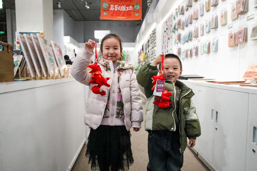 1月26日晚,在甘肃省博物馆文创商店,小朋友展示刚购买的新款马踏飞燕贺岁毛绒玩偶“红运当头马”。新华社记者 郎兵兵 摄