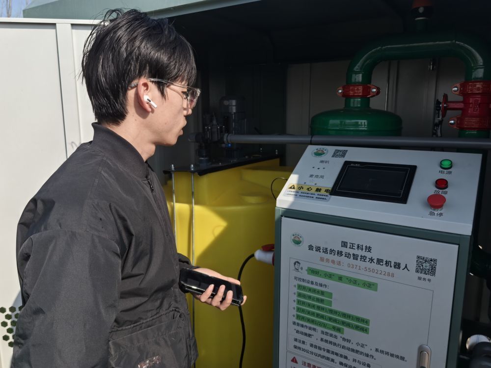 2026年3月19日，河南省濮阳市清丰县惠农农机农民专业合作社的工作人员在智控水肥机器人前，通过语音完成水泵开关、施肥、不同阀门开合等操作。新华社记者马意翀 摄