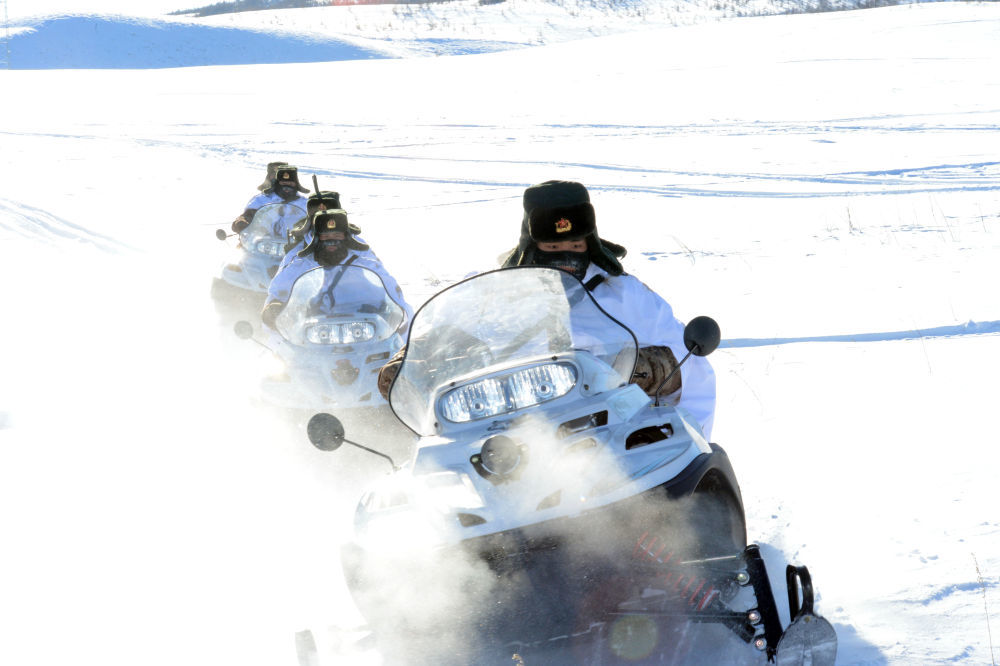 北部战区陆军某旅三角山边防连官兵驾驶摩托雪橇执勤。新华社发（2014年1月摄）
