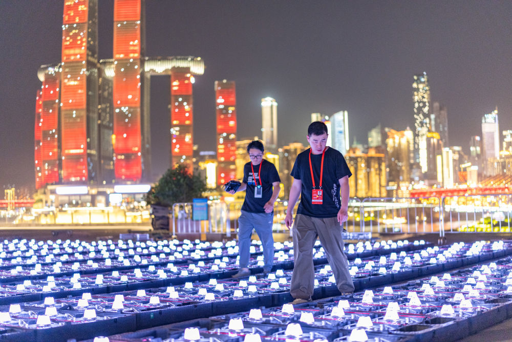 2025年5月1日晚,在重庆市南岸区,无人机群飞行规划员检查将用于无人机灯光秀的无人机。新华社记者 黄伟 摄