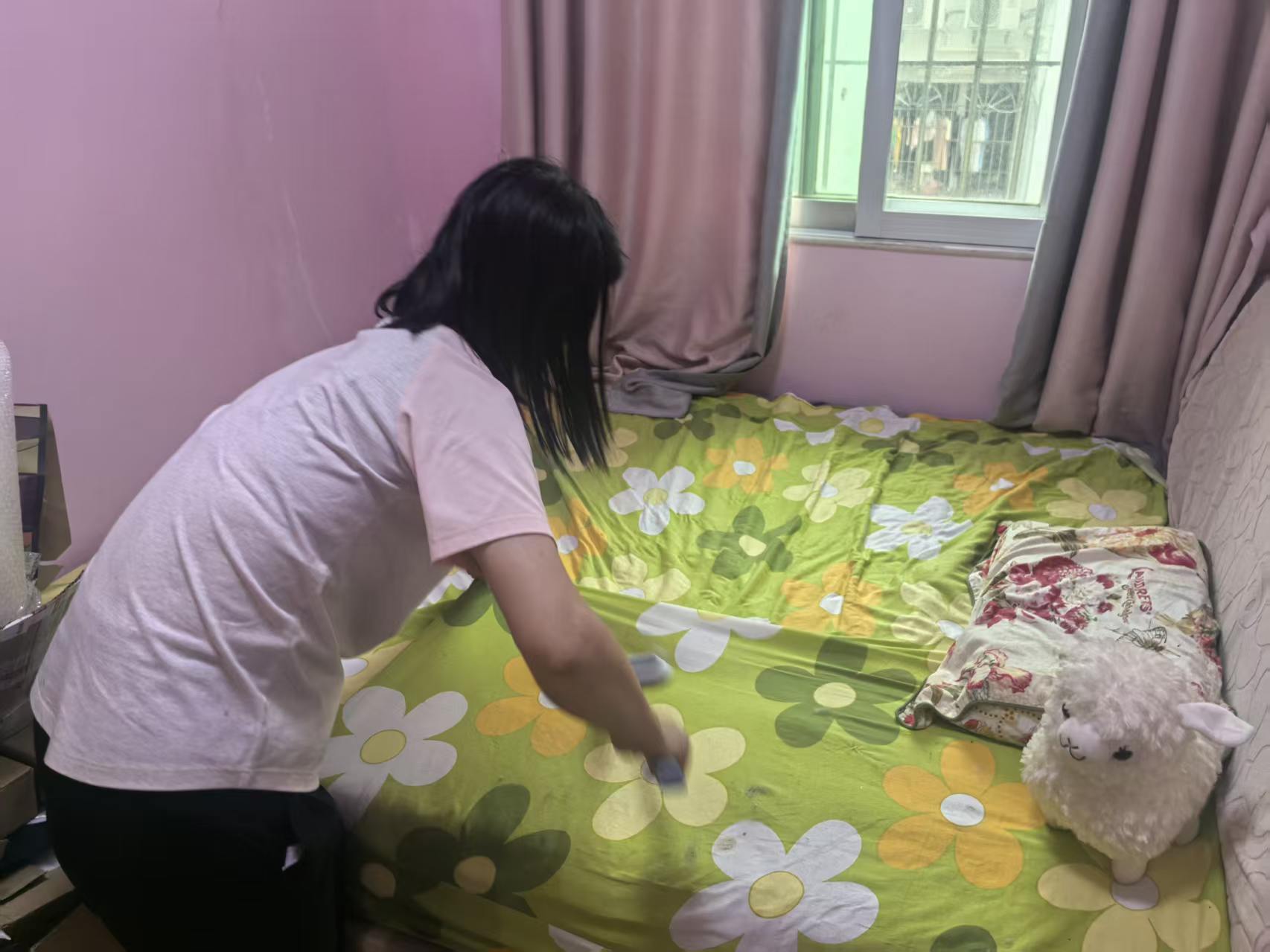 △吴梅在打扫女儿生前躺过的床铺。