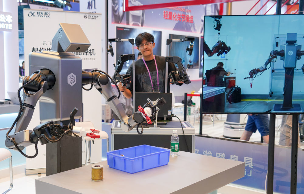 2025年10月16日,工作人员在第138届广交会科大讯飞展台操作机器人拿取物品。新华社记者 肖恩楠 摄