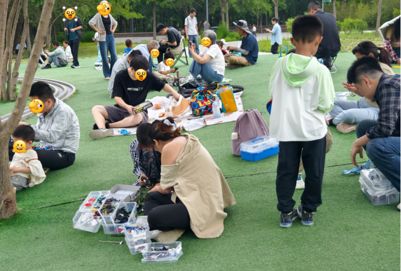 温榆河公园赛道旁,家长与孩子正在修四驱车。(图/记者拍摄)