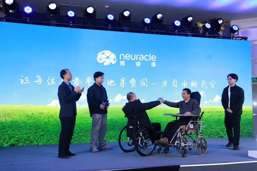 董辉(右二)在NEO无线微创植入脑机接口多中心GCP注册临床试验总结会上,徒手抓起水杯喝水,这是他瘫痪多年无法实现的 / 图源:上海科技