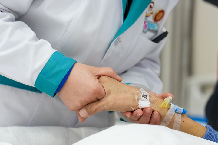 2月5日，在丰台区蒲黄榆社区卫生服务中心，医务社工郭翠红（左一）握着一位70岁的癌症患者的手和她交流。新华每日电讯记者鞠焕宗 摄