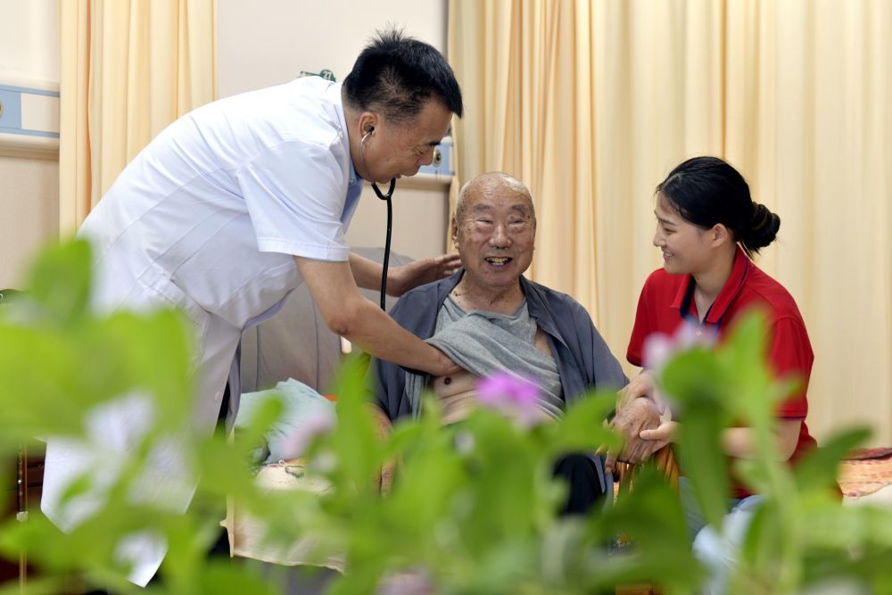 2025年8月20日，在山东省郓城颐合养老服务中心，医生魏登芹为参保职工长护险的秦增节检查身体。新华社记者 郭绪雷 摄