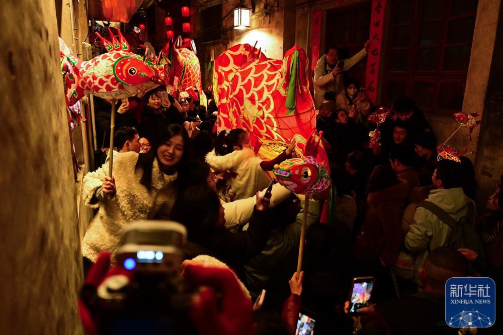 2月7日,游客在瞻淇村里体验鱼灯表演。