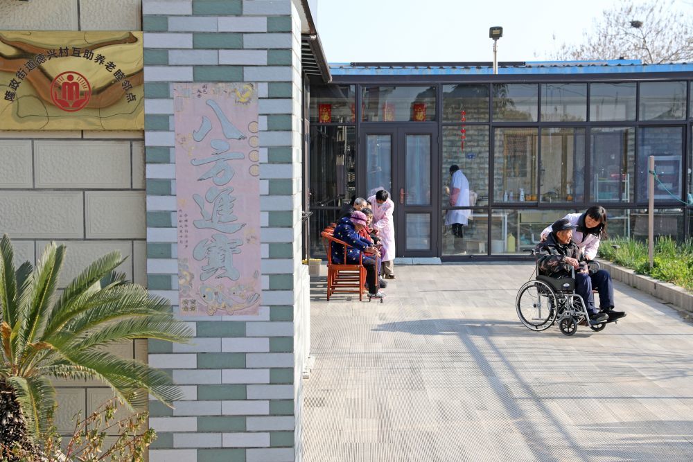 2025年12月28日，在江苏省海安市，老人们在护理人员陪同下晒太阳。新华社发（顾彬斌 摄）