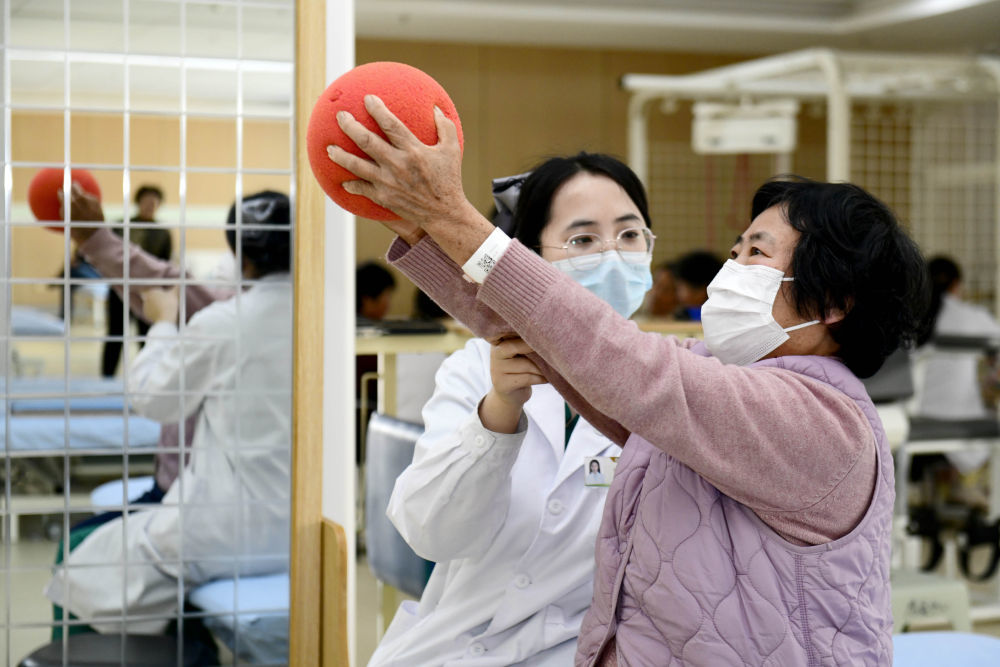 3月25日，在山东日照市康复医院，医护人员协助老人做康复训练。新华社记者 郭绪雷 摄