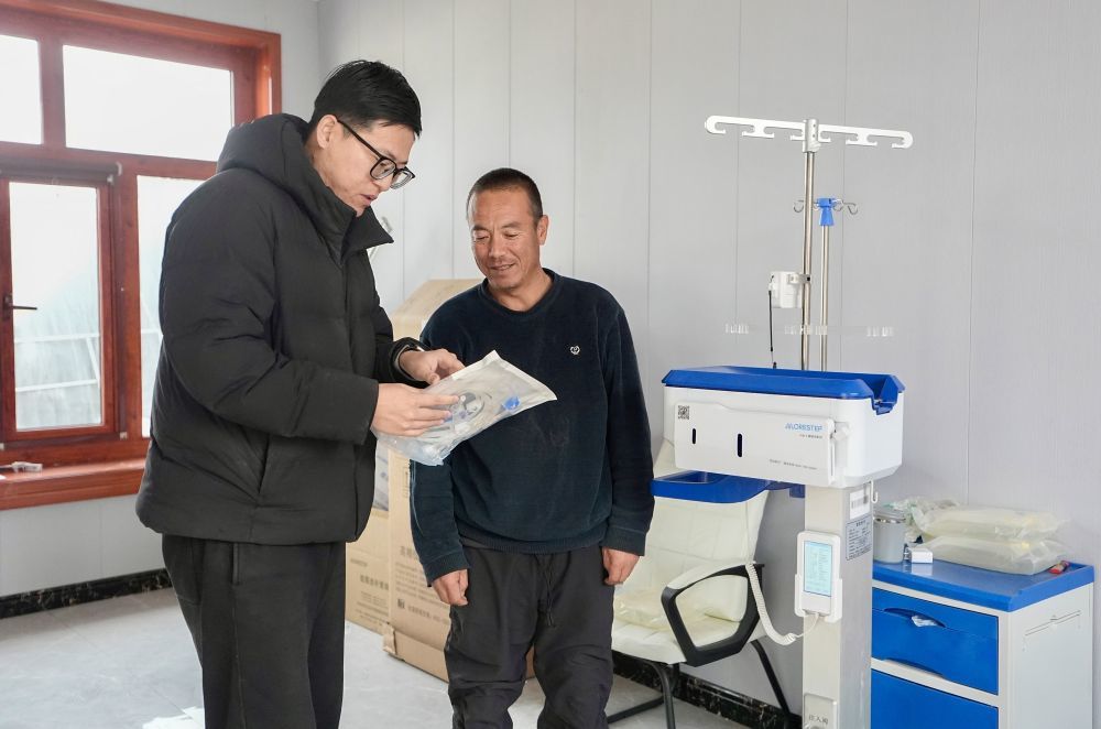 2月2日，宁夏固原市原州区彭堡镇惠德村驻村帮扶工作队工作人员为村民马文军（右）讲解租用的医疗器械及配套耗材的使用方法。新华社记者 杨植森 摄