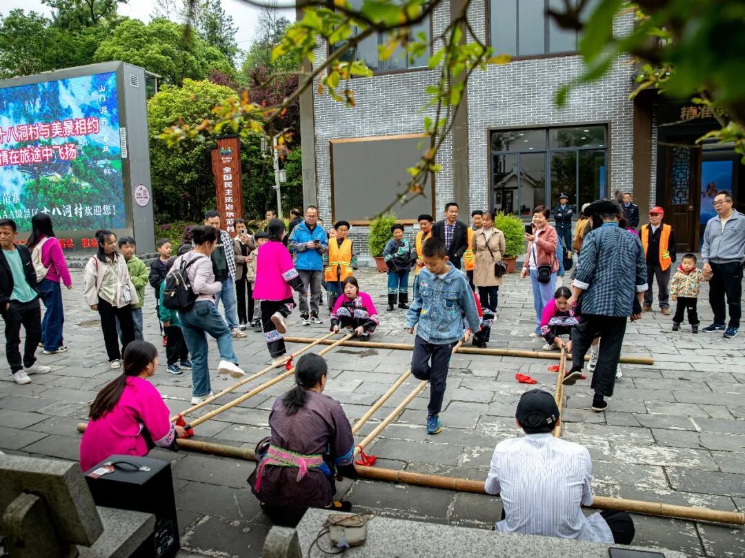 游客在十八洞村体验竹竿舞项目。石林荣摄（中经视觉）