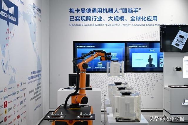 在雄安人工智能产业园一层展厅,工业机器人在演示货物搬运。(牟宇 摄)