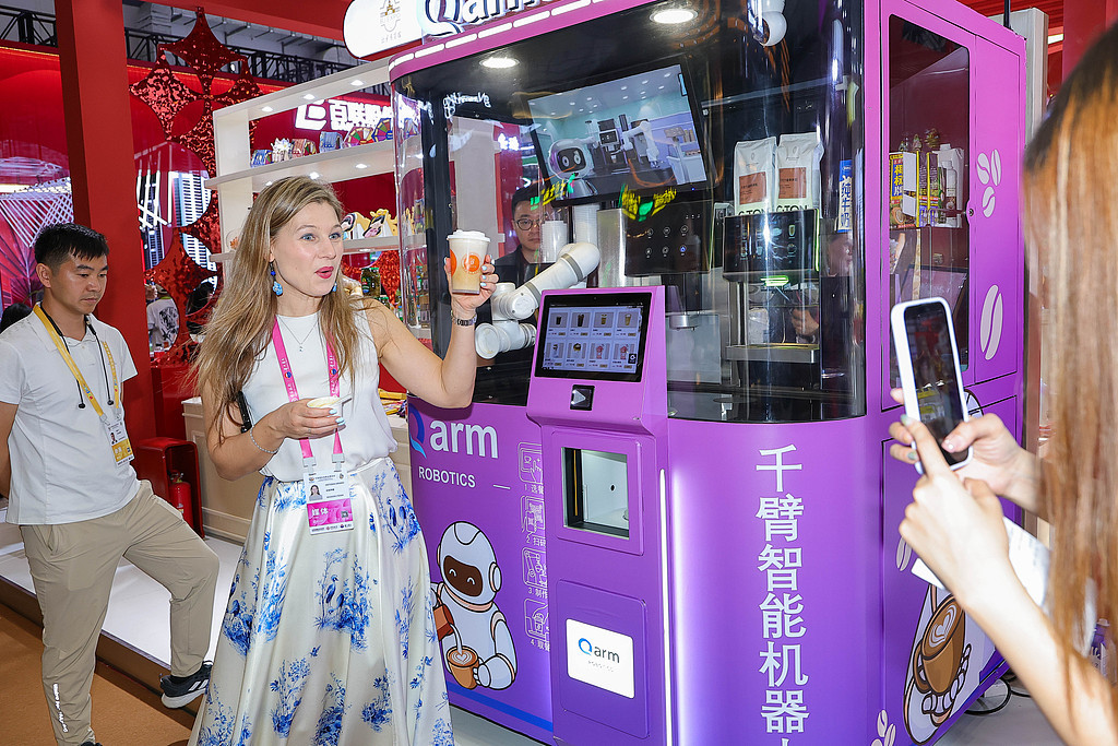 一位外籍网络主播品尝中国智能机器人制作的咖啡。（视觉中国）