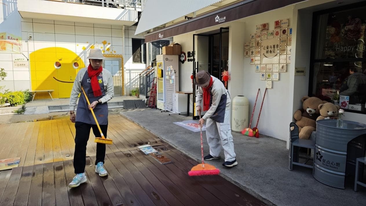 杰希（左）和宇宏（右）在打扫店外卫生（记者江晓晨 摄）
