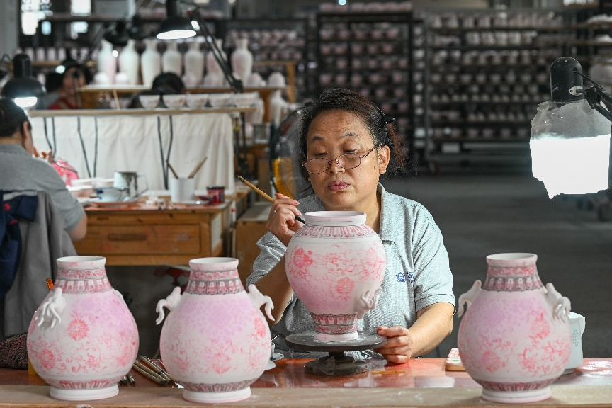 2026年7月7日,江西景德镇,工匠在进行手绘工序,在坯体上绘制各种花面图案。 中新社发 王宇轩 摄
