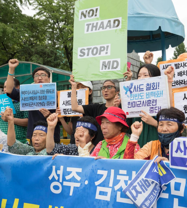 2017年7月31日，在韩国首尔国防部门前，韩国民众高举反对部署“萨德”系统的标语参加抗议集会。新华社发（李相浩摄）