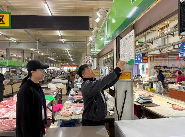 和平市场内的管理人员核对每日菜价