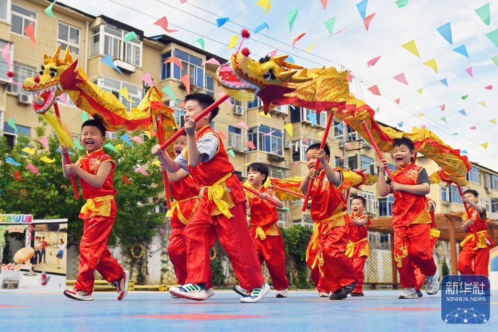 ↑ 6月17日,在山东省烟台市福山区实验幼儿园,小朋友表演舞龙。新华社发(孙文潭摄)