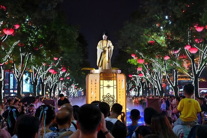 西安大唐不夜城的演员“李白”与游客对诗互动(2024年7月9日摄)。新华社记者 邹竞一 摄