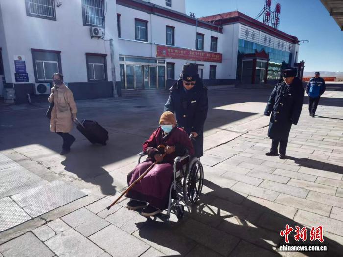 图为青藏铁路那曲站客运工作人员帮助腿脚不便的老人乘车。拉萨车务段 供图