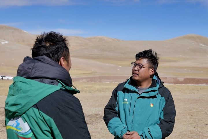 达瓦顿珠(右一)在巡护中和长江源环保志愿队队员交流。新华每日电讯记者 周昱龙 摄