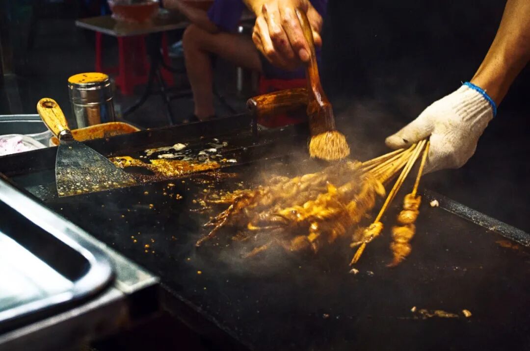 摄图网_701903827_夜市烧烤摊刷酱料烤制肉串_(企业商用).jpg